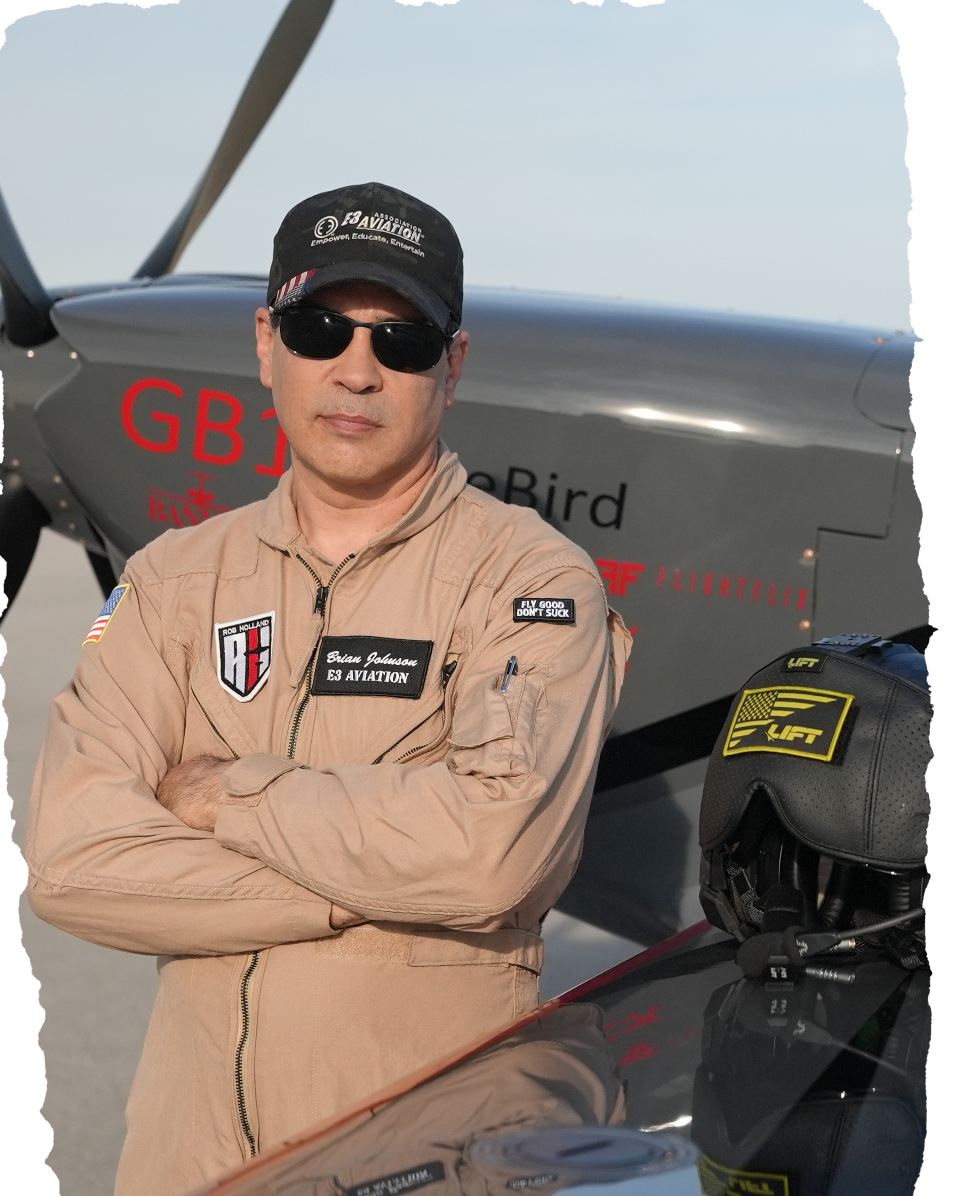 Brian Johnson, Founder & CEO of E3 Aviation Association, in flight suit beside his GameBird aerobatic aircraft